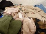 a pile of clothes on a bed with a tag on it