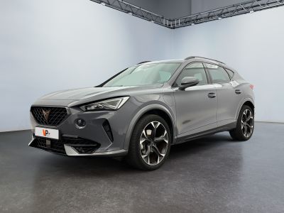 a grey car parked in a large room with a white wall