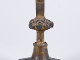 une vieille croix en bronze ornée d'une pierre verte en son centre