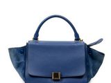 un petit sac à main bleu avec une boucle dorée sur la poignée