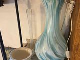 a blue and white vase sitting on a table next to a cup