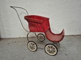 a small red baby stroller with a basket on it