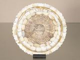 a clock made of shells on a stand on a table