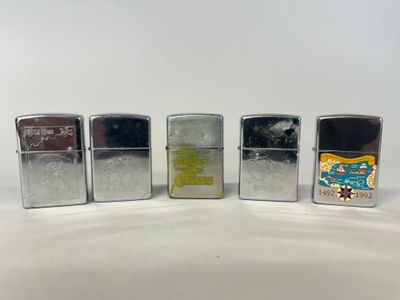 quatre briquets sont alignés sur une surface blanche