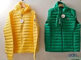 yellow and green vests hanging on a wall next to each other
