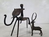 statue représentant un chat assis sur une chaise à côté d'un cerf
