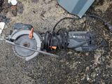 a circular saw sitting on the ground next to a piece of metal
