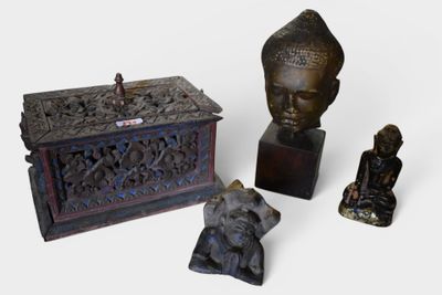 three statues of buddhas and a box on a table