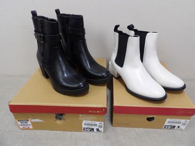 Deux paires de bottes noires et blanches sont posées sur une boîte.