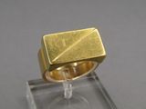 une photo d'une bague en or posée sur le dessus d'une vitrine transparente