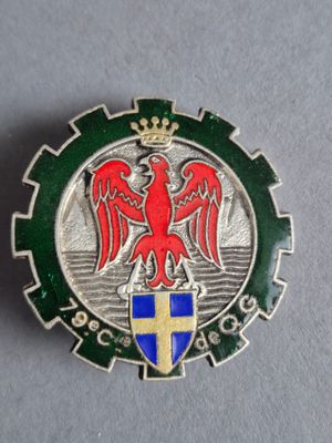 une image représentant un insigne métallique orné d'un aigle rouge