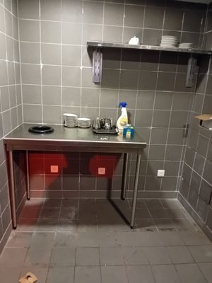 une cuisine équipée d'un évier, d'une cuisinière et d'étagères