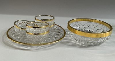 three glass cups and saucers on a plate with gold rims