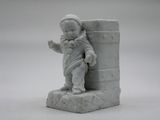 a small statue of a little boy holding a book