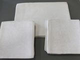 three white napkins sitting on top of a table next to each other