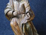 statue of a man sitting on a chair with a book in his lap