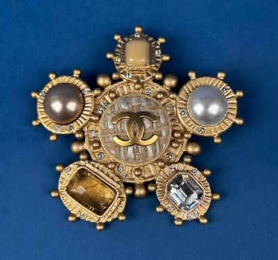 an image of a gold broochle with pearls and stones