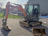 a small excavator that is sitting on the side of the road