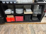 many plates and glasses on a shelf in the kitchen