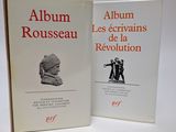 deux livres posés sur une table blanche, dont l'un a une couverture rouge et l'autre une photo en noir et blanc