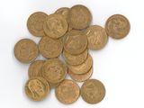 une pile de pièces d'or sur une surface blanche