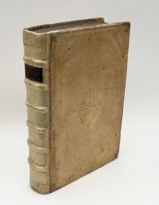 an old book sitting on top of a white table next to a white wall