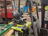 a yellow fork truck parked in a warehouse next to other pallets