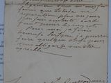 un vieux papier sur lequel est écrite une lettre à la main, posé sur une table