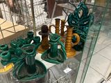 une vitrine en verre remplie de vases verts et de bougies