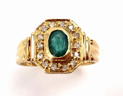 a close up of a ring with a green stone surrounded by diamonds