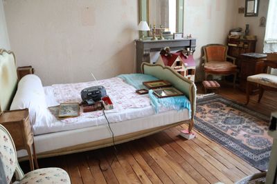 une chambre avec un lit, une chaise, un bureau et un miroir