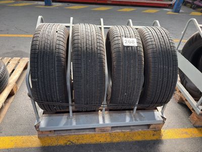 three tires are stacked on a pallet in a warehouse