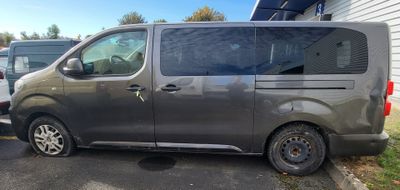 a grey van parked in a parking lot next to a white van