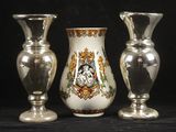 trois vases en argent posés l'un à côté de l'autre sur une table