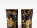 two black and gold vases sitting next to each other