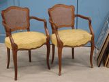 pair of cane back chairs with yellow upholstered upholstered cushions