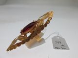 Gros plan sur une bague en or ornée d'une pierre rouge