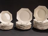 plusieurs assiettes blanches empilées les unes sur les autres sur une surface noire