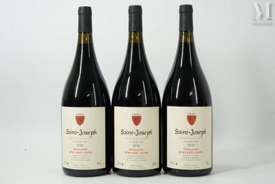 trois bouteilles de vin sont posées sur une surface blanche