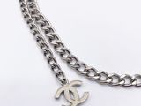 a close up of a silver chain with a chanel logo on it