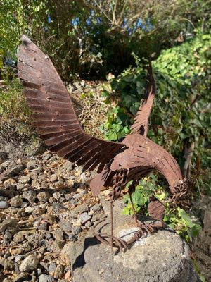 a statue of a bird that is on a rock