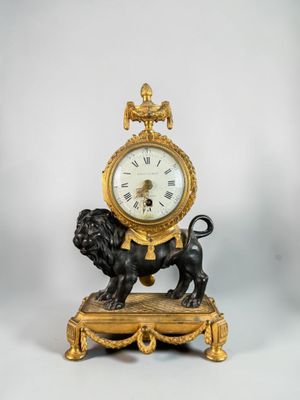 a gold clock with a lion on top of it