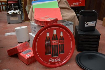 un plateau rouge sur lequel se trouve un Coca-Cola, à côté d'autres objets