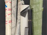 many rolls of fabric on the floor next to each other