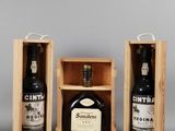 three bottles of wine in wooden boxes on a gray surface