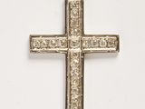 a close up of a silver cross on a white background