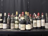 bottles of wine are lined up on a table in front of a black backdrop