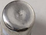 a silver container on a white surface with a silver lid