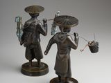 pair of bronze figurines of asian men with umbrellas and baskets