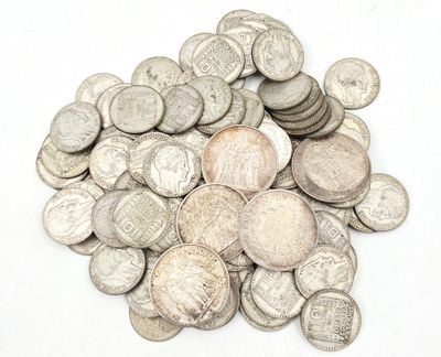 une pile de pièces d'argent posée sur une surface blanche